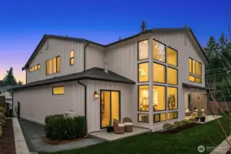 Modern rear elevation with expansive windows and architectural detail.