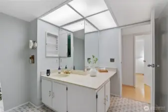 This functional guest bath features a spacious vanity area with abundant counter space and a large mirror, offering a bright and comfortable place to start and end the da