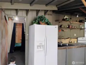 Storage area with workbench and staged bunkhouse to left of outdoor kitchen