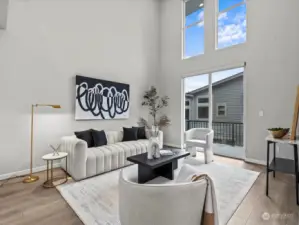 Large, open concept living room with two-story ceilings and windows.