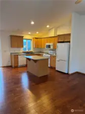 Kitchen island with eating bar and open to kitchen and dining area.