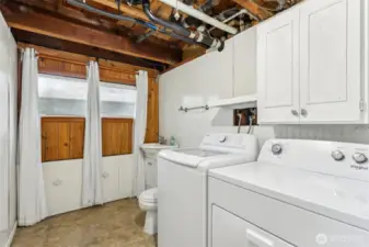 Brand new washer/dryer in utility room w/toilet and sink.