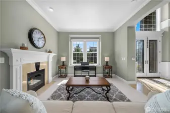 Expansive picture window floods the living space with light, highlighting the fireplace and welcoming entry.
