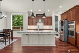 Spacious kitchen island with quartzite counters, pendant lighting, and seating space for casual dining.