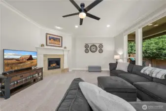 Spacious family room centered around a cozy fireplace, perfect for relaxing or entertaining.