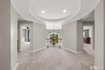 The upper rotunda landing offers a dramatic architectural focal point, with curved walls, recessed lighting, and views overlooking the grand foyer.
