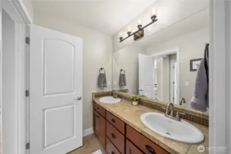 Double sinks with warm tile counters and stylish fixtures, designed for both function and comfort.