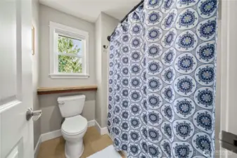 Full bath with tiled tub/shower and private toilet area, thoughtfully separated from the vanity for added convenience to family or guests.
