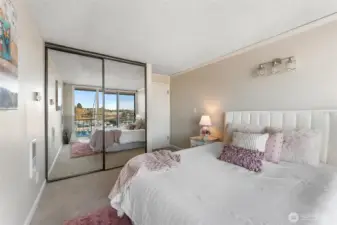 Alternate view of the primary bedroom highlighting mirrored closets and abundant light.