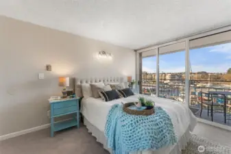 Primary bedroom with direct access to the balcony and sweeping water views.