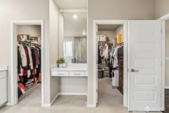 Wrap around walk in closet in primary with vanity station