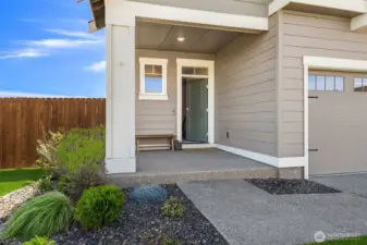Lovely covered entry with 3-car garage and spacious front yard