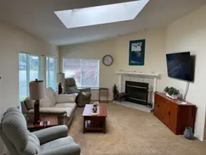 Living Room with fireplace and skylight.