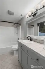 UPPER LEVEL | The primary suite bathroom features a bath/shower combo with 2 showerheads.