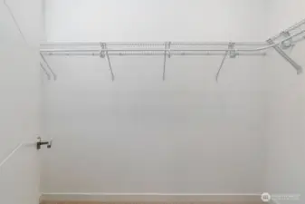 Walk-in closet off primary suite. On the other side of the closet door to the left is a lovely window for natural light while in the closet.