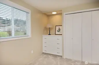 The guest bedroom has a built-in dresser and views of the backyard.