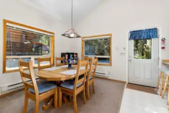 Dining area with large windows overlooking the natural wooded setting.