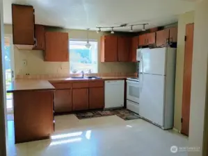 Efficient kitchen with a garden window overlooking most of the fenced acreage'