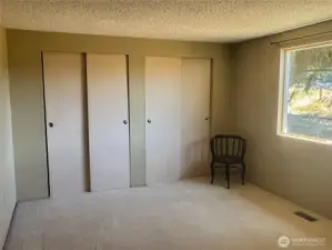 Primary bedroom with double closet and view to the acreage.