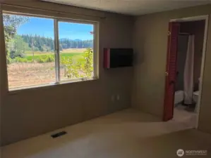 Large double window with a view of the Olympic Mountains and lovely landscape. Full bathroom en suite.