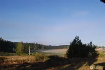 Fog has almost dissipated and mountains are becoming visible in the distance.