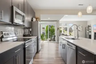 Cooking is a dream in this beautifully appointed kitchen, equipped w/ stainless steel appliances, quartz counters, full tile backsplash & abundant storage in sleek custom cabinetry.