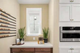 Adjacent workspace/bar off of kitchen provide additional storage