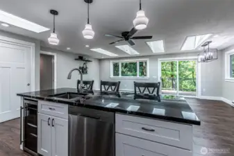 Looking into the great room from the kitchen, note the skylights, recessed lighting and more windows for tons of natural light