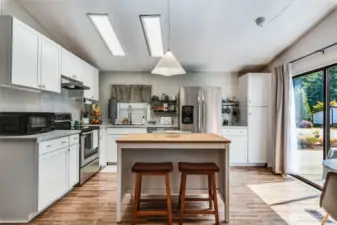 Bright and modern remodeled kitchen with NEW: center island, Shaker cabinets, countertops, flooring & lighting.