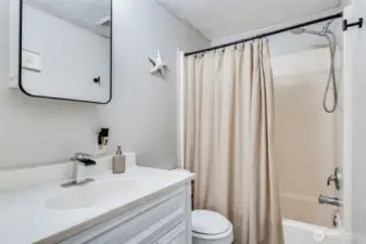 Full guest bathroom with shower/tub combo w/NEW: vanity, toilet, medicine cabinet & lighting.