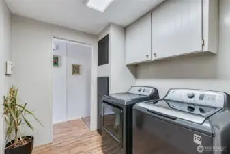Laundry room with full-size washer and dryer (included!); plus overhead cabinets for storage.