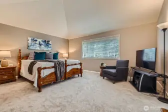 Primary bedroom with vaulted ceilings offers respite at the end of the day.