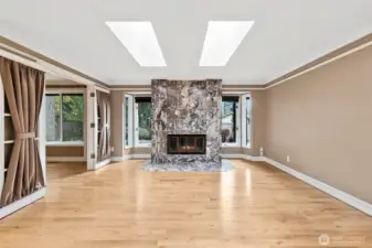 Walk into a large living room with a beautiful marble fireplace.  The doors to the left are french doors leading into one of the two dens on the main floor.