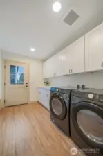Huge Laundry Room with cabinets and mud room bench