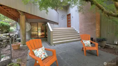 Inviting outdoor seating area at the private entry, perfect for morning coffee or evening unwinding and pulled together with a calming water feature and mature mimosa tree.