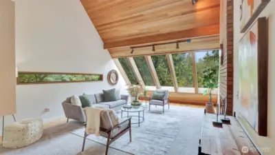 Enter to this one-of-a-kind living space, where expansive windows flood the room with natural light and vaulted ceilings create an airy, open feel.