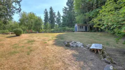 Spacious yard featuring a storage shed and ample space for recreation or gardening.