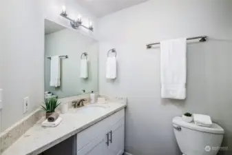 The main bathroom features a tub / shower combination and a new vanity / quartz combination.