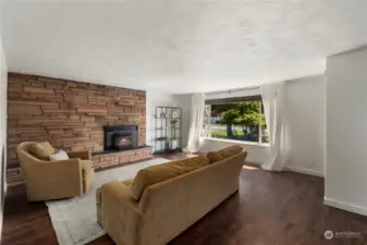 With the dramatic brick that surrounds the fireplace & warm colored flooring, this living room has the perfect ambiance.
