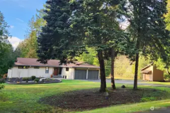 Front view showing the new landscaping, garden shed, off-street/RV parking and tranquil setting.