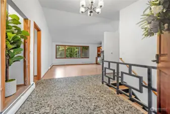 Entry foyer with vaulted ceiling, aggregate floor and new chandelier.