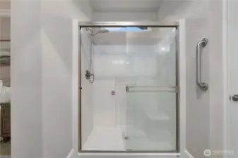 Easy care shower with an upgraded shower door and a bench.