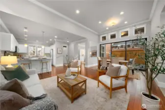 The spacious great room with vaulted ceilings, crown molding, gleaming Engineered hardwoods and the stunning 3-panel rolling wall of glass.