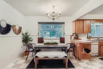 Bright dining space with wainscoting detail and backyard views, conveniently open to the kitchen.