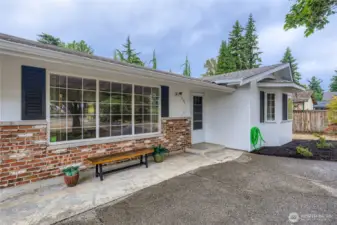 Charming front entry with brick accents and a wide picture window, offering a warm welcome