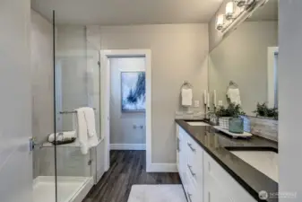 Luxurious primary bath...double vanity with quartz counters, lots of storage, beautiful shower with bench and frameless shower doors, plus private water closet.