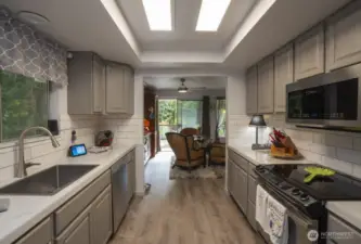 galley kitchen, led lighting into dining area