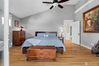 Primary bath with vaulted ceilings, hardwood floors, bonus sunroom and deck with water view