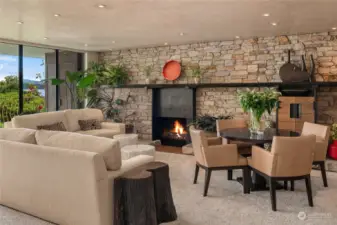 A custom stone wall and steel fireplace surround anchors the living room.