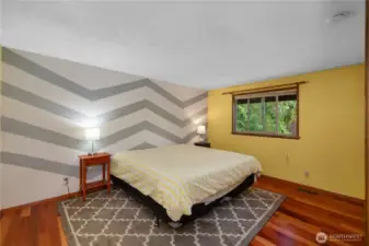 2nd BR with chevron accent wall and more wood floors.